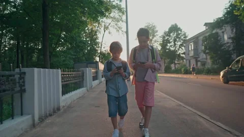 The schoolboys returning from school in a sunset time. Stock Footage 157822563