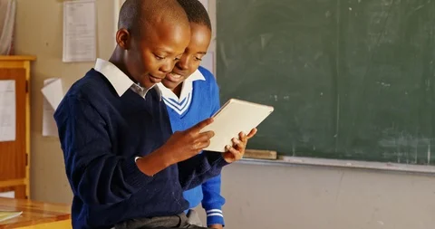 Schoolboys using a tablet during a break at a township school 4k Vidéo 114247704