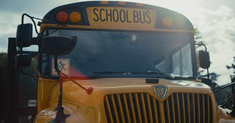 Schoolbus front staying on empty parking with yellow sign image children closeup Stock Photos