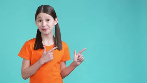 Schoolchild demonstrate empty space offer isolated cyan color background Stock Footage 190178104