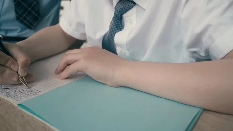 Schoolchildren do homework, write numbers in notebook Stock Footage 105098494