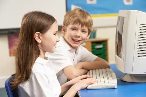 Schoolchildren In IT Class Using Computer Stockfoto's
