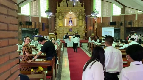Schoolchildren line in a single queue to take their first communion Stock Footage 234890523