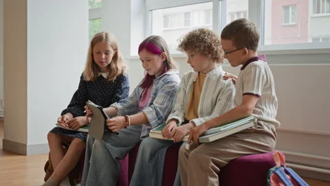 Schoolchildren Using Digital Tablet for Collaborative Learning Stock Footage 345823384