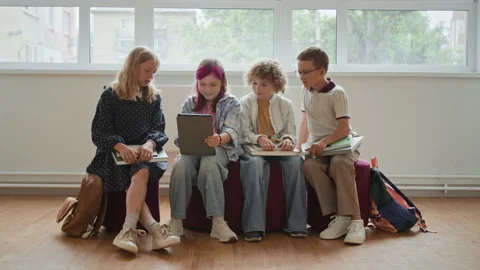Schoolchildren Using Digital Tablet Together in School Hallway Stock Footage 345222433