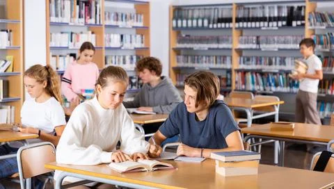 Schoolchildren write out a synopsis from the textbook Stock Photos