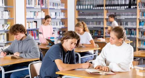 Schoolchildren write out a synopsis from the textbook Stock Photos