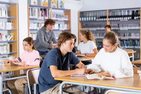 Schoolchildren write out a synopsis from the textbook Stock Photos