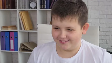 Schooler boyusing tablet computer for online education at home. Kid enjoys Stock Footage 233725524