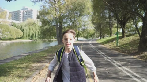 Schoolgirl boy with a backpack run through the park home from school dream on a Stock Footage 140082848