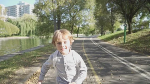 Schoolgirl boy with a backpack run through the park home from school dream on a Vídeos de archivo 140083102