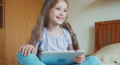 Schoolgirl child using tablet pc in the bedroom Stock Footage 55883666