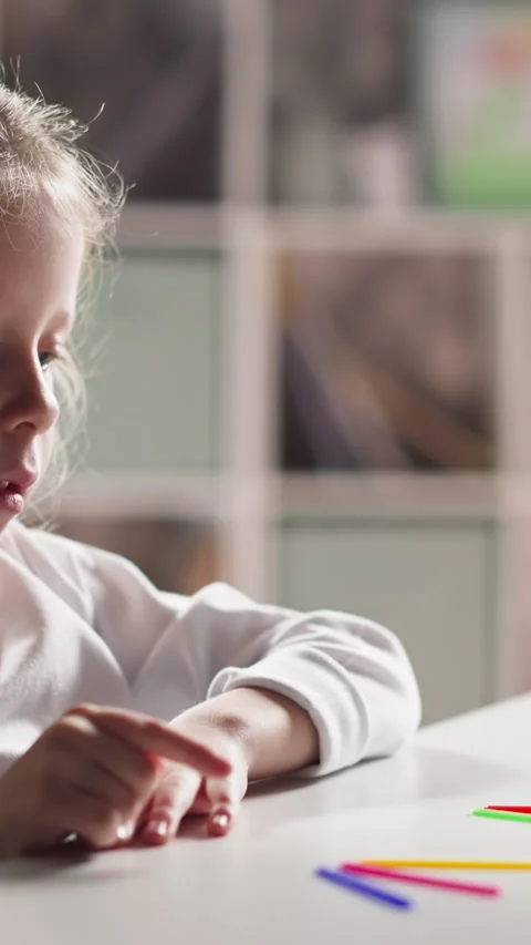 Schoolgirl counts aloud sticks solving problem at lesson Stock Footage 310864530