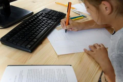 Schoolgirl does lessons in front of the computer Foto stock