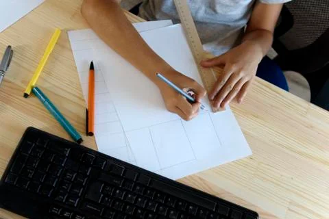 Schoolgirl does lessons in front of the computer, view from above. Stock Photos