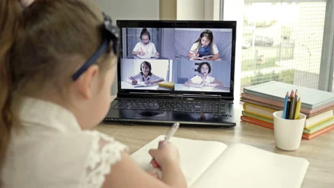 Schoolgirl in front of a laptop screen performs school assignments. On the Stock Footage 144176442