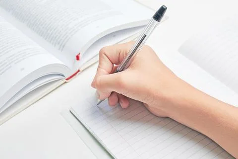 Schoolgirl is going to write in a notebook. homework solution Stock Photos