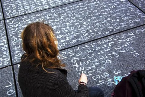 A schoolgirl has written a maths problem on a pavement. Austria Stock Photos