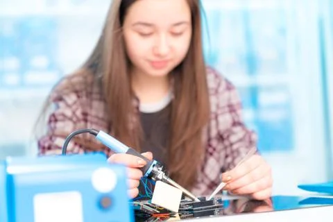 Schoolgirl in laboratory robots debug microcontroller Stock Photos
