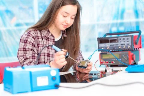 Schoolgirl in laboratory robots debug microcontroller Foto stock
