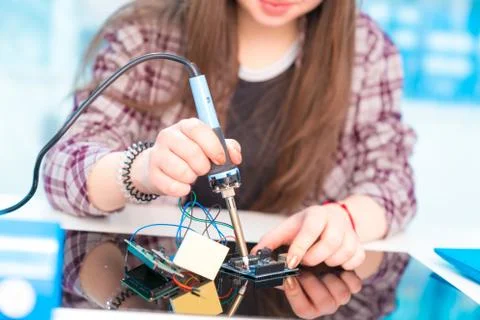 Schoolgirl in laboratory robots debug microcontroller Foto stock