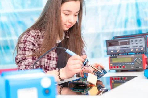 Schoolgirl in laboratory robots debug microcontroller Stock Photos