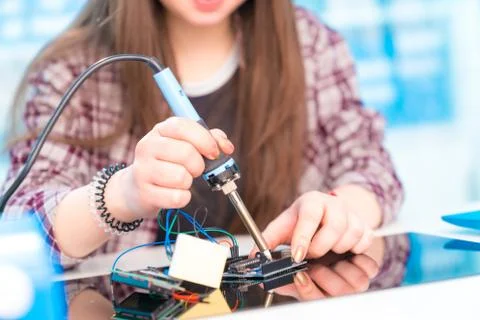 Schoolgirl in laboratory robots debug microcontroller Foto stock