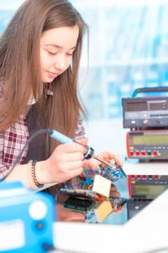 Schoolgirl in laboratory robots debug microcontroller Foto stock