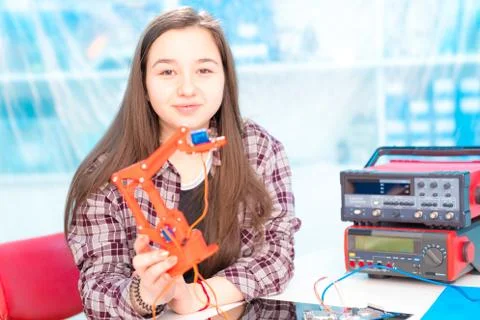 Schoolgirl in laboratory robots debug microcontroller Foto stock