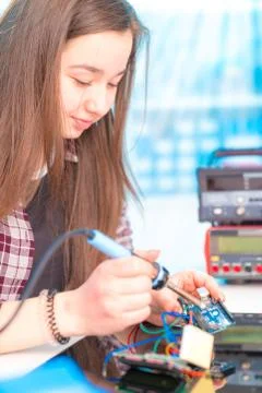 Schoolgirl in laboratory robots debug microcontroller Foto stock