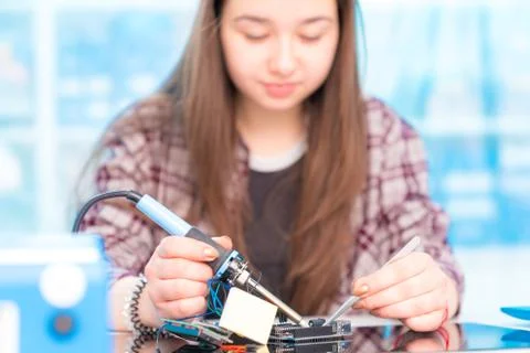 Schoolgirl in laboratory robots debug microcontroller Stock Photos