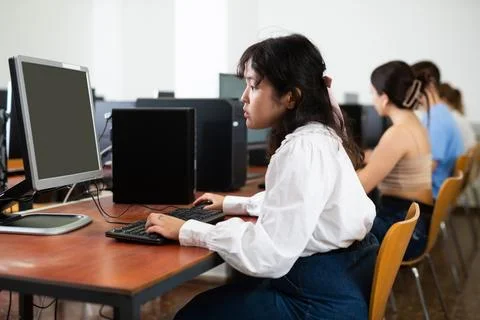 Schoolgirl learning basics of programming in group course in computer college Foto stock