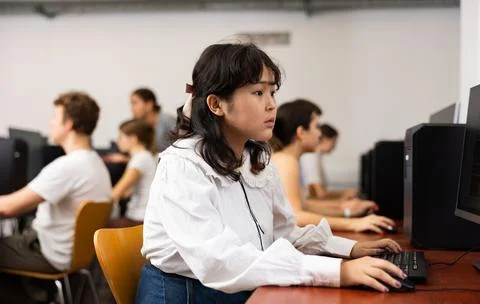 Schoolgirl learning basics of programming in group course in computer college Stock Photos