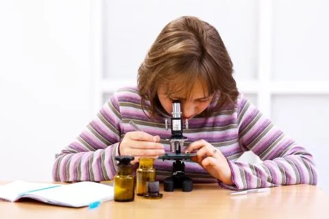 Schoolgirl with microscope Stock Photos
