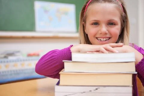 Schoolgirl posing with a stack of books Stockfoto's