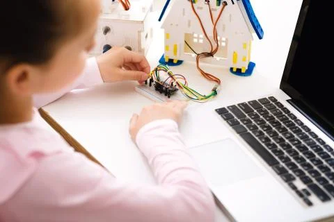 Schoolgirl programming robot with laptop computer at lesson Foto stock