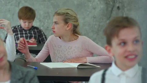Schoolgirl putting on glasses during lesson Stock-Footage 77737853