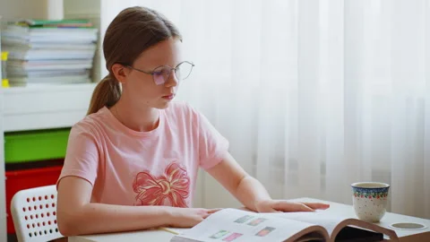 Schoolgirl reading and taking notes 스톡 동영상 259362277