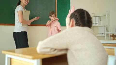 Schoolgirl solving math problem on chalkboard with teacher guidance Stock Footage 339330802