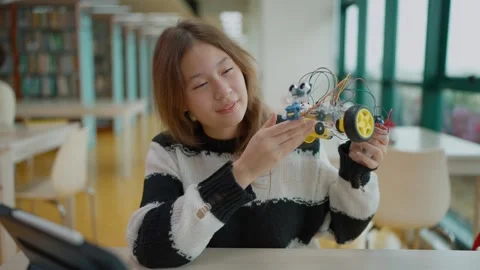 Schoolgirl student presenting model robot car directly to camera. STEM education Stock Footage 320400614