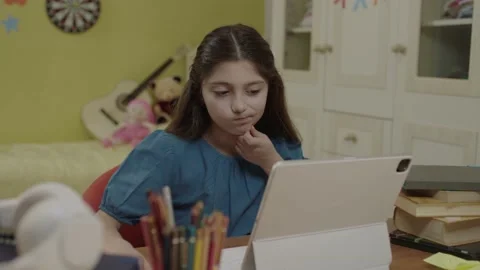 Schoolgirl studying online using tablet computer taking notes in her notebook. Stock Footage 203716703