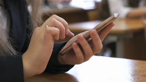 Schoolgirl typing the text using a mobile phone Vídeo Stock 79976832
