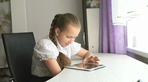 Schoolgirl uses a digital tablet computer at home Stock Footage 68148603
