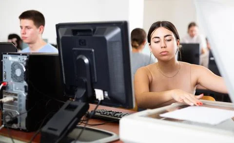 Schoolgirl uses a scanner in the computer class of school Stock Photos