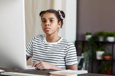 Schoolgirl using computer at home Stock Photos