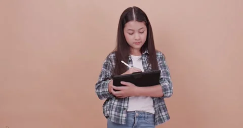 Schoolgirl using computer tablet to study and take notes. Video stock 260364702