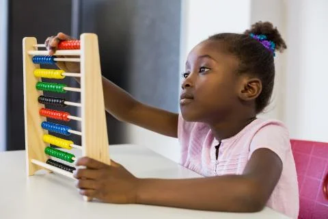Schoolgirl using a maths abacus in classroom Stock Photos