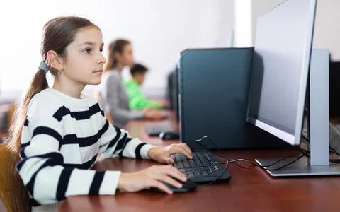Schoolgirl using PC during computer science lesson 스톡 사진