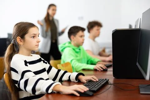 Schoolgirl using PC during computer science lesson Stock Photos