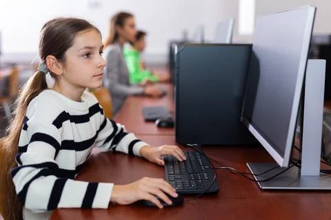 Schoolgirl using PC during computer science lesson 스톡 사진